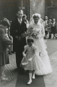 875879 Afbeelding van het bruidspaar P.A. (Piet) Bronius en M.H. (Rie) Noorland, met een bruidsmeisje dat bloemetjes ...